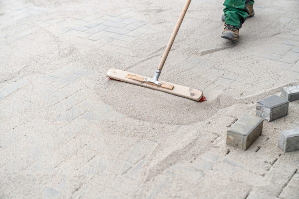 sweeping sand on the new pavement